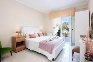 a white bedroom with a bed and a balcony at Villa INVA Korfu in Kavos