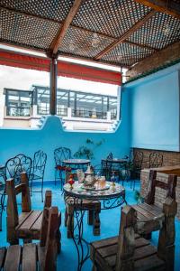 a room with a table and chairs and a blue wall at Dar Chbili Fès in Fez