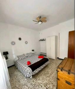 a bedroom with a black and white bed and a ceiling fan at Hogar dulce hogar. in Águilas