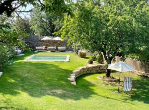 a yard with a swimming pool and an umbrella at Le Boudoir proche Montignac, Hautefort in Saint-Rabier