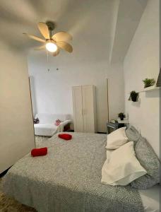 a bedroom with a bed with red pillows and a ceiling fan at Hogar dulce hogar. in Águilas