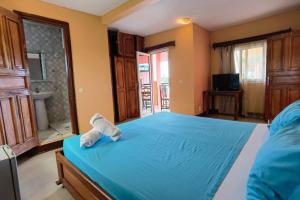 a bedroom with a bed with a stuffed animal on it at Hôtel Concorde in Antsiranana