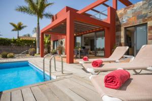 a villa with a swimming pool and lounge chairs at Las Terrazas Villa 3 in Salobre