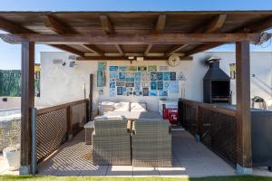 a wooden pergola with a table and a stove at Sunset- Spa and Bbq in Calafell