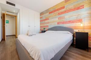 a bedroom with a large bed and a wooden wall at Sunset- Spa and Bbq in Calafell