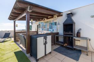 a patio with an outdoor kitchen with a stove at Sunset- Spa and Bbq in Calafell