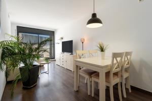 a dining room with a white table and chairs at Sunset- Spa and Bbq in Calafell