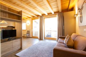 a living room with a couch and a television at Appartamento Sant'Antoni Fontana in Livigno