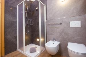 a bathroom with a shower and a toilet and a sink at Appartamento Sant'Antoni Fontana in Livigno +21 photos