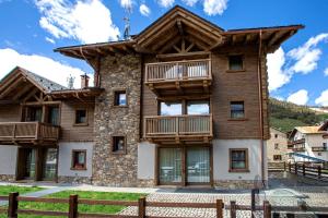 a large wooden house with a balcony at Appartamento Sant'Antoni Fontana in Livigno