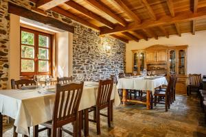 a dining room with tables and chairs and a stone wall at Casa da Penela in Mondoñedo +78 photos