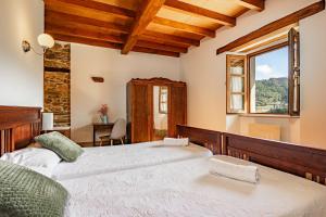 a bedroom with two beds and a window at Casa da Penela in Mondoñedo