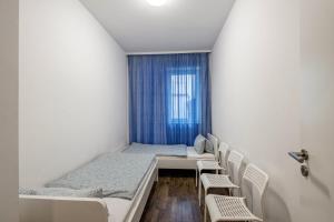 a room with two beds and chairs and a window at Ferienwohnung Alex in Leipzig