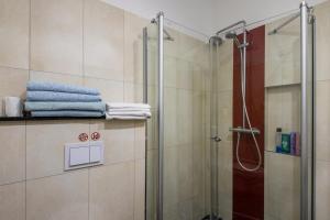 a bathroom with a shower with towels on a shelf at Ferienwohnung Alex in Leipzig +12 photos
