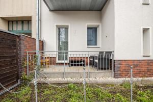 a house with a fence and stairs in front of it at Ferienwohnung Alex in Leipzig