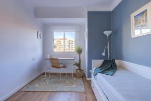 a bedroom with a bed and a desk and a window at Vivir en Valencia in Valencia