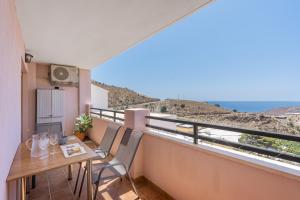 a balcony with a table and chairs and a view of the ocean at Piso Haza in Haza del Trigo