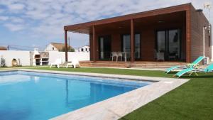 a villa with a swimming pool and a house at Casa Toria in Conil de la Frontera