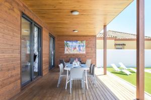 a dining room with a table and chairs on a deck at Casa Toria in Conil de la Frontera