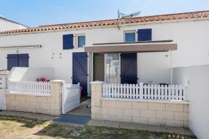 a white house with a white picket fence at La Pause Iodée - 500 m mer in La Tranche-sur-Mer
