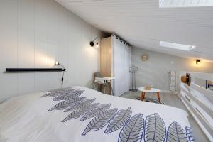 a bedroom with a bed with a blue and white blanket at La Pause Iodée - 500 m mer in La Tranche-sur-Mer