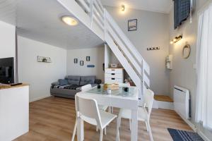 a white dining room with a white table and chairs at La Pause Iodée - 500 m mer in La Tranche-sur-Mer