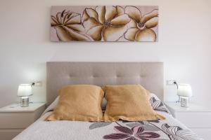a bedroom with a bed with two lamps and a painting on the wall at Piso Haza in Haza del Trigo