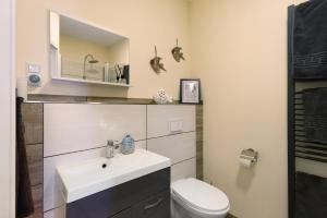a bathroom with a sink and a toilet at Süsse 2 Zimmerwohnung in Heiligenstedten +9 photos
