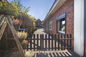 a wooden fence in front of a house with potted plants at Süsse 2 Zimmerwohnung in Heiligenstedten