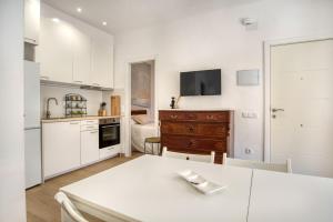 a kitchen with white cabinets and a table in a room at Old Side Platja d Aro in Platja d'Aro +20 photos