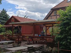 a man standing outside of a building with tables and chairs at Veronika in Wesenberg