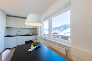 a kitchen with a table and a large window at Hus Appartement - Nr. 5 in Valdaora