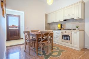 a kitchen with a table and chairs and a stove at Gma Home Primo Piano in Pulsano