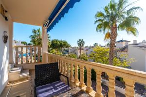 a balcony with a chair and a palm tree at Sunnygolfbeach in Orihuela Costa