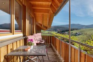 a balcony with a table and chairs and a view at Stockerhof in Elzach