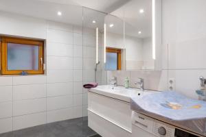 a white kitchen with a sink and a mirror at Stockerhof in Elzach +60 photos