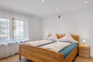 a bedroom with a wooden bed with a window at Stockerhof in Elzach
