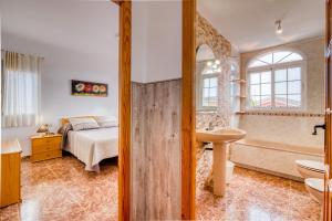 a bedroom with a bed and a tub and a sink at Chalet Bonavista in Benifayó +24 photos