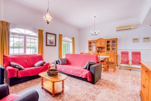 a living room with two red couches and a table at Chalet Bonavista in Benifayó