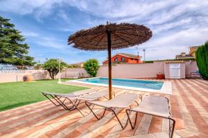 a patio with two chairs and an umbrella next to a pool at Chalet Bonavista in Benifayó