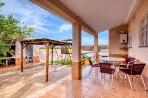a patio with a table and chairs and a playground at Chalet Bonavista in Benifayó