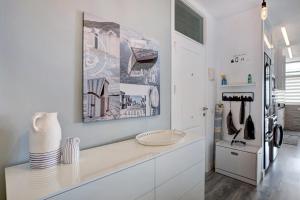 a white kitchen with a counter with a vase on it at Mi casa de Radazul in El Rosario +21 photos