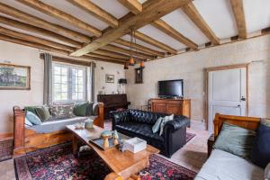 a living room with a couch and a tv at Le Logis de Cléré in Cléré-les-Pins