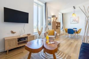 a living room with a couch and a tv and a table at Le nid des Perdrix in Île-Tudy