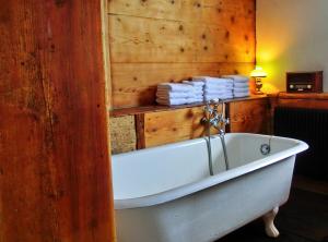 a white bath tub in a room with towels at Schwarzwaldbauernhaus Bernau in Bernau im Schwarzwald