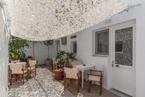 a patio with a table and chairs and a chandelier at A Tinian Room 5 in Tinos +14 photos