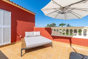 a patio with a chair and an umbrella at Casa de Tina in Llucmajor