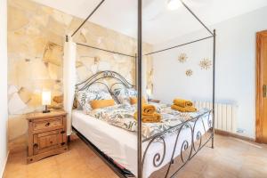 a bedroom with a canopy bed and a wooden nightstand at Casa de Tina in Llucmajor +22 photos