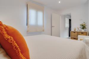 a white bedroom with a bed and a window at Casa Jica in La Orotava