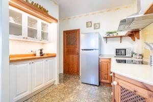 a kitchen with white cabinets and a refrigerator at Can Xuri in Campos